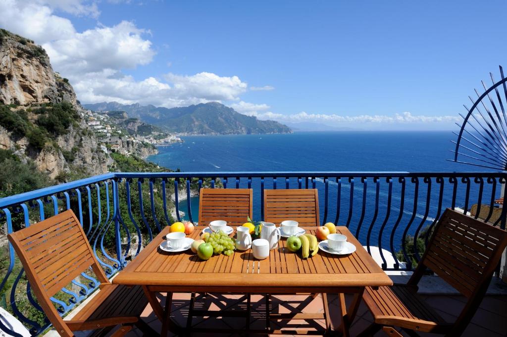 a wooden table with fruit on top of a balcony at L'ancora in Conca dei Marini