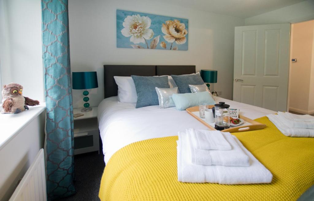 a bedroom with a large bed with a yellow blanket at Park House in Basingstoke