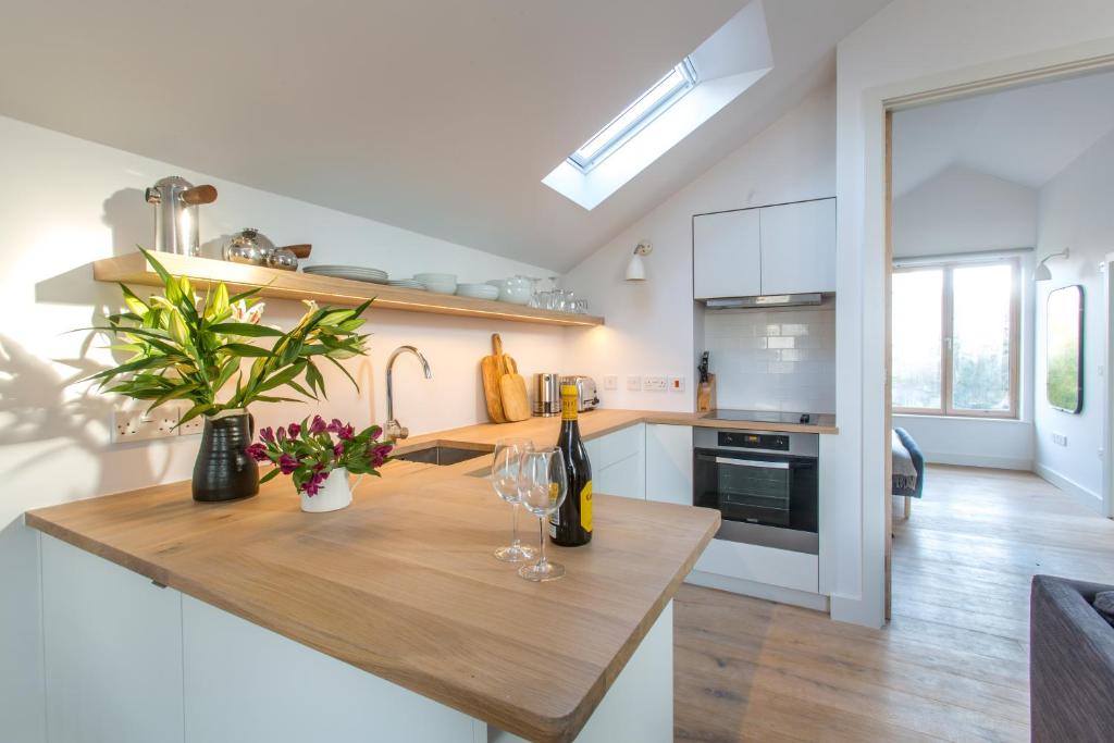 - une cuisine avec un comptoir en bois et des verres à vin dans l'établissement Laurel Studio, à Aldeburgh