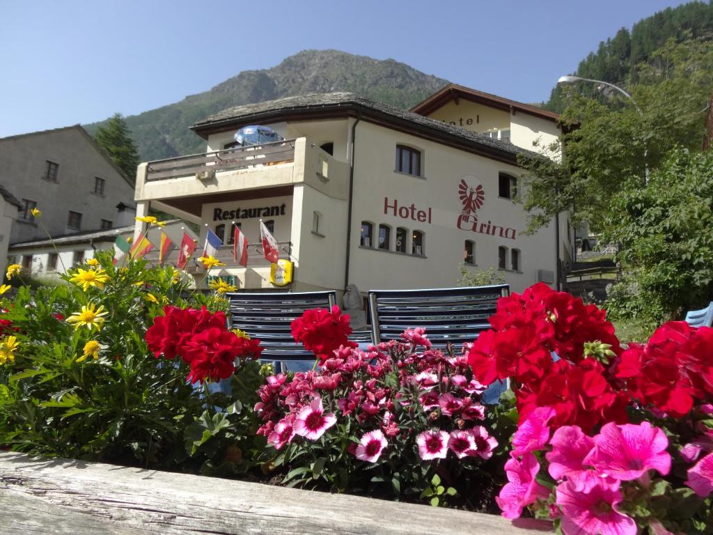 un grupo de flores frente a un edificio en Hotel-Restaurant Grina en Simplon Dorf