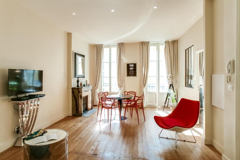 ein Wohnzimmer mit roten Stühlen und einem Tisch in der Unterkunft Appartements Cathédrale - YBH in Bordeaux