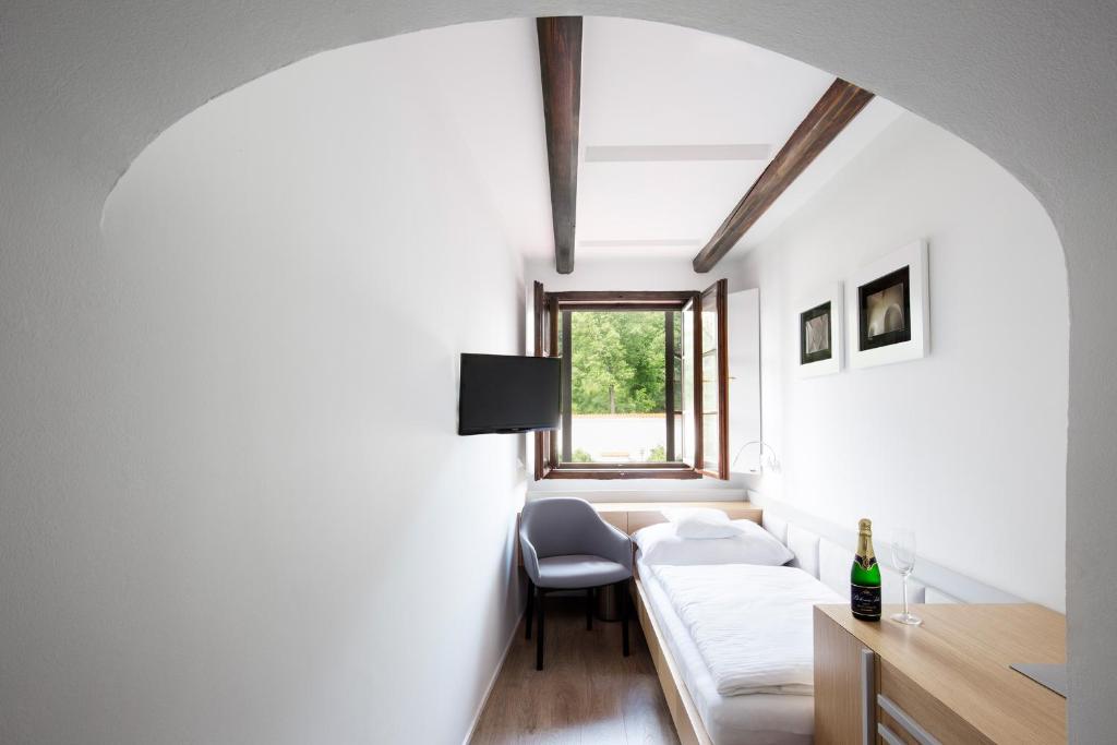 a room with a couch and a table and a window at Hotel 100 in Pardubice