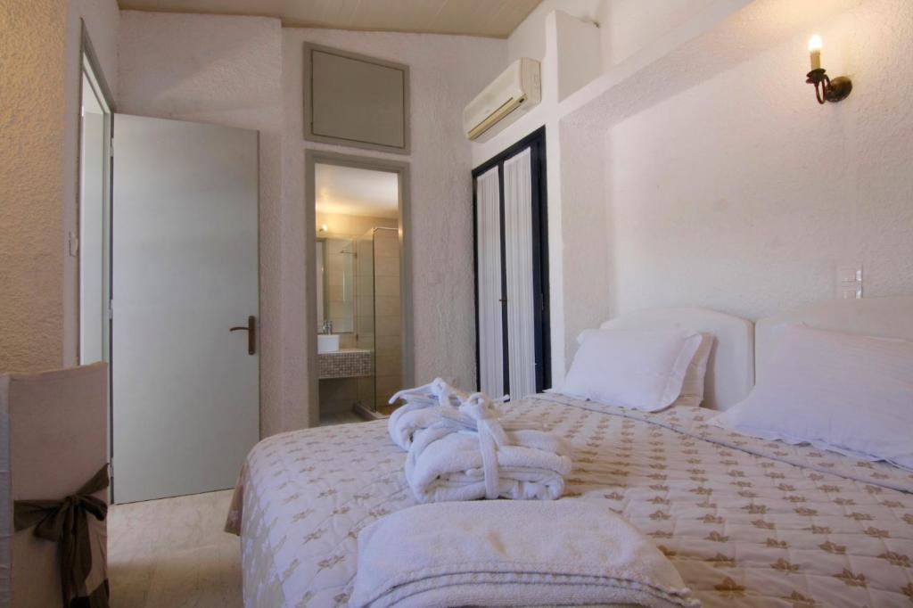 a white bedroom with a bed with towels on it at Mare Vista Hotel - Epaminondas in Batsi