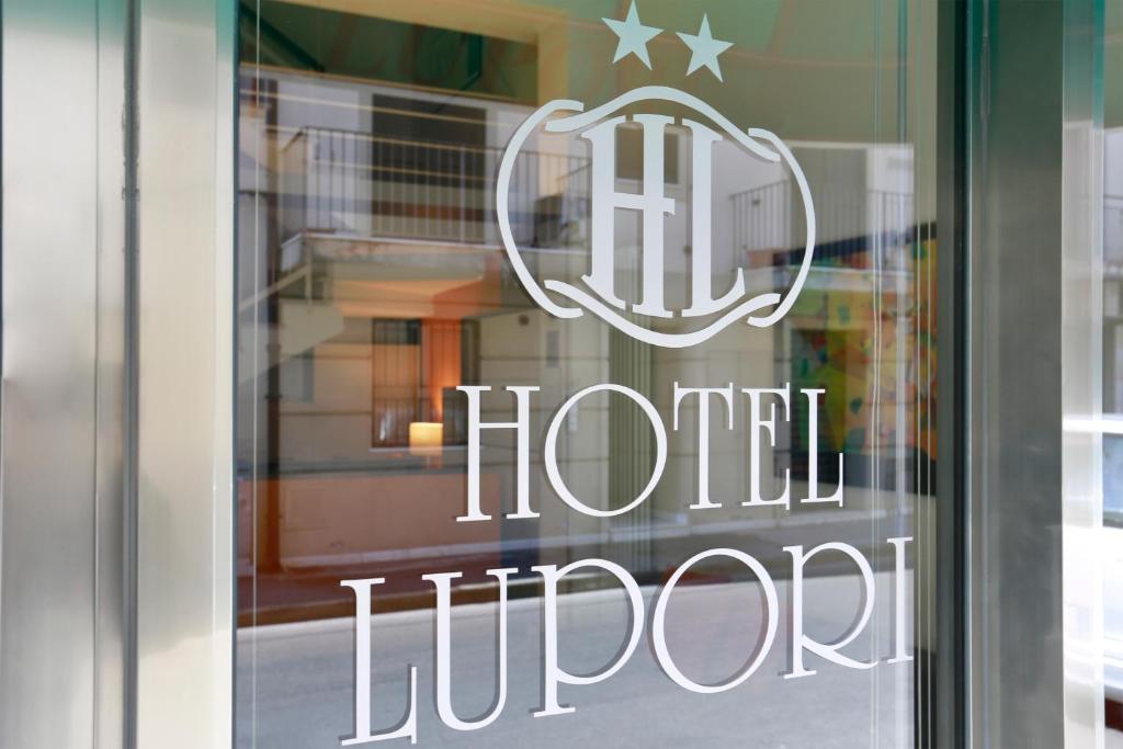 a sign on a window of a hotel lobby at Hotel Lupori in Viareggio