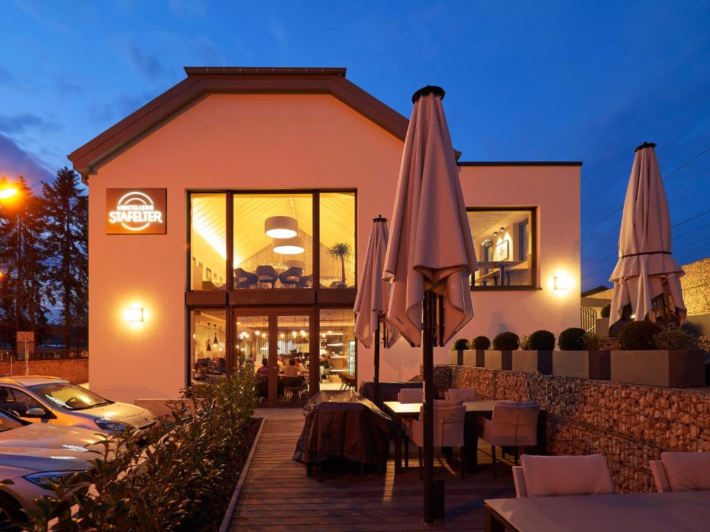 a restaurant with tables and umbrellas in front of a building at Hostellerie Stafelter in Walferdange