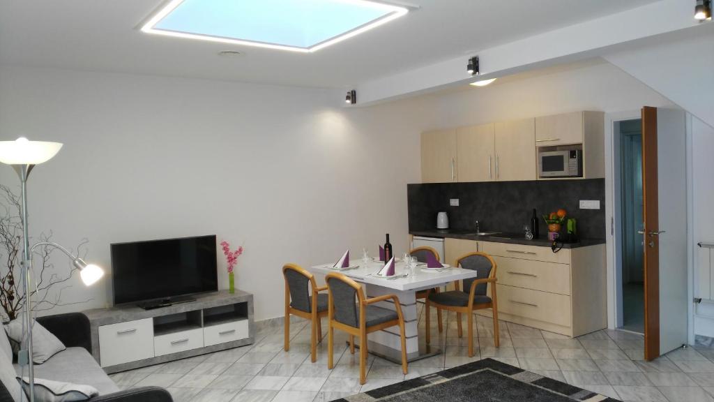 a kitchen and dining room with a table and chairs at Füredi Ház apartman in Sopron