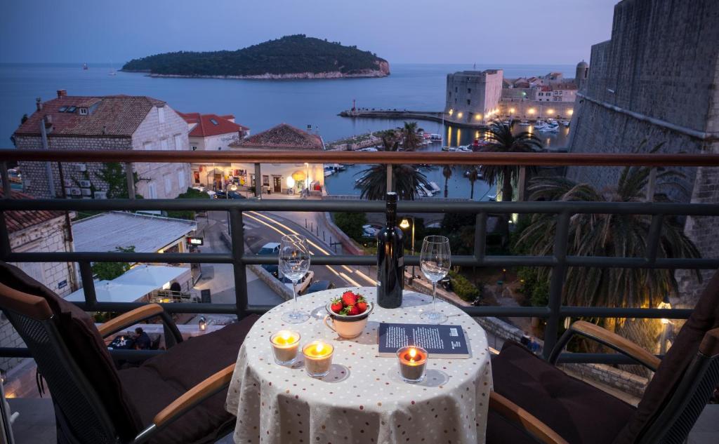 - une table avec des verres à vin et des bougies sur le balcon dans l'établissement Ragusina luxury apartments, à Dubrovnik