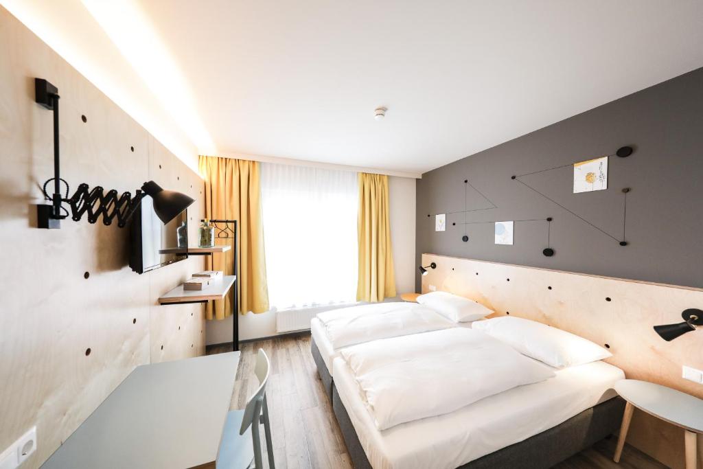 Schlafzimmer mit einem großen weißen Bett in der Unterkunft Hotel Tullnerfeld in Tulln
