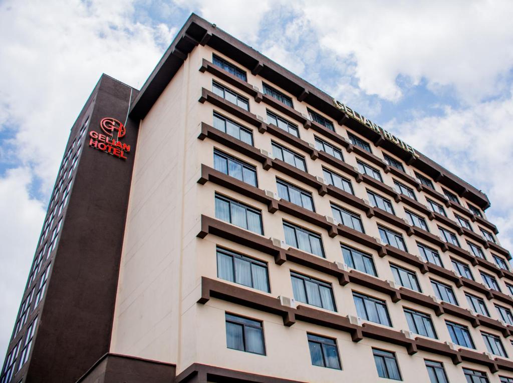 ein hohes weißes Gebäude mit einem roten Schild darauf in der Unterkunft Gelian Hotel in Machakos