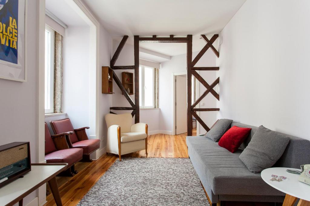 a living room with a couch and a tv at JOIVY Inviting flat next to Carmo Convent in Lisbon