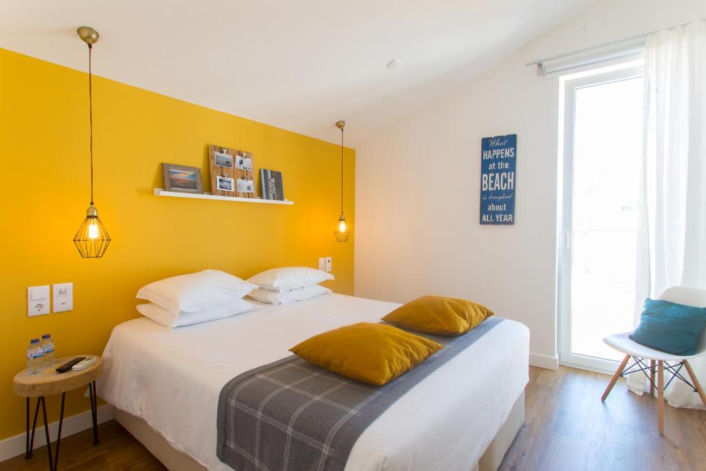 a bedroom with a bed with a yellow wall at Aveiro Rossio Bed & Breakfast in Aveiro