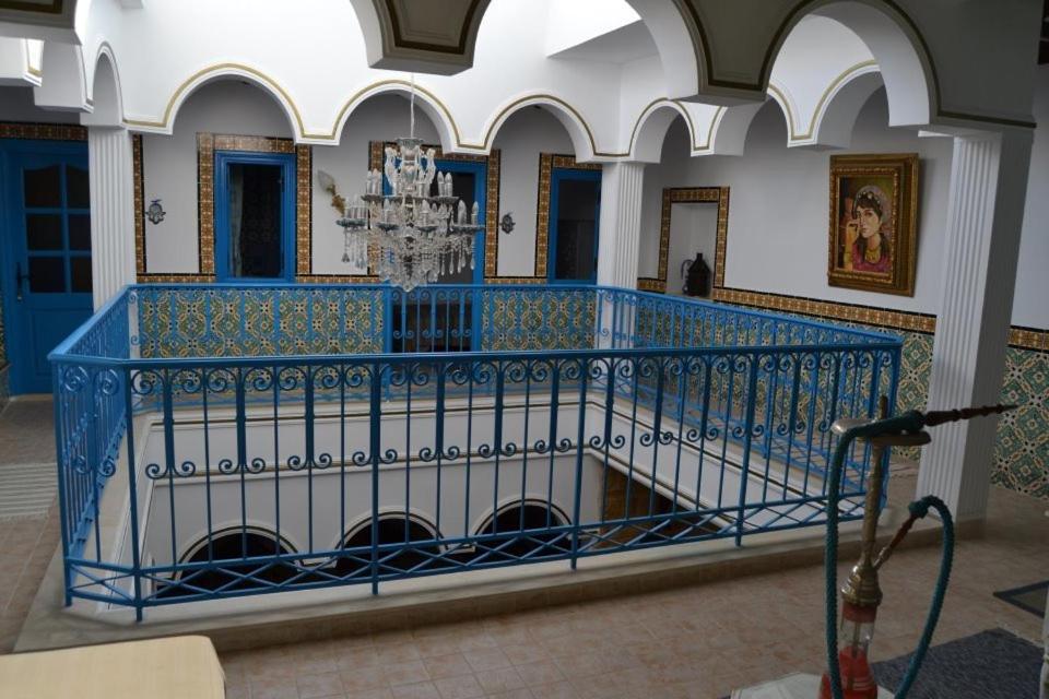 vestíbulo con barandilla azul y lámpara de araña en Dar El Kasba Bizerte en Bizerte