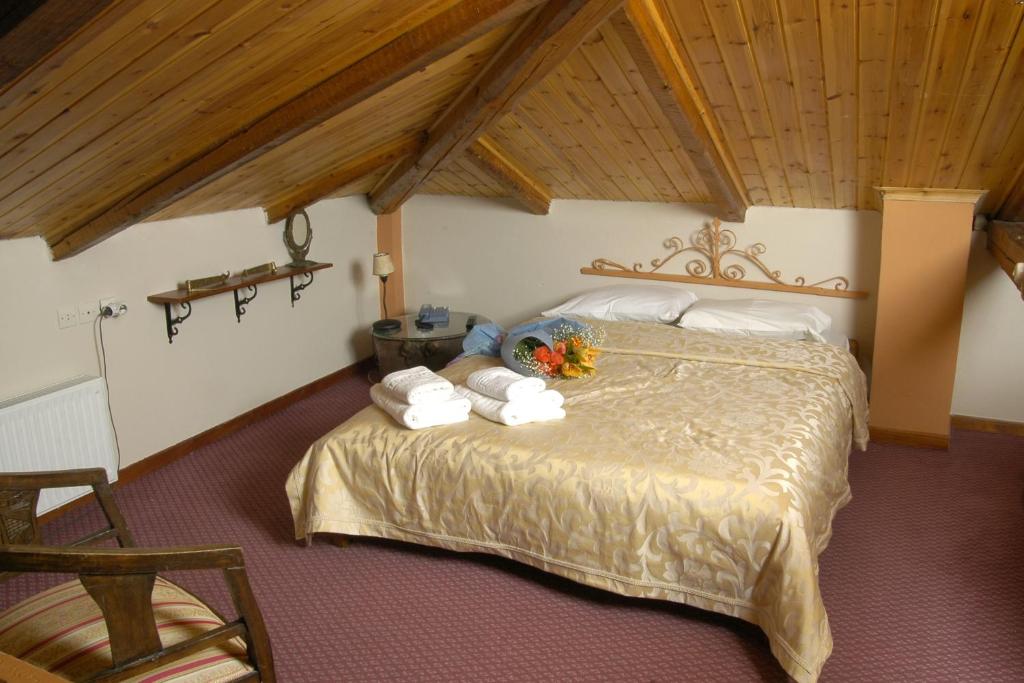 Filoxenia Studios في غالاكسيدي: غرفة نوم بسرير كبير عليها مناشف