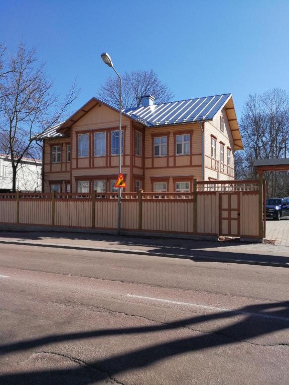 una casa grande con una valla de madera y un edificio en Esplanad Apartment en Mariehamn