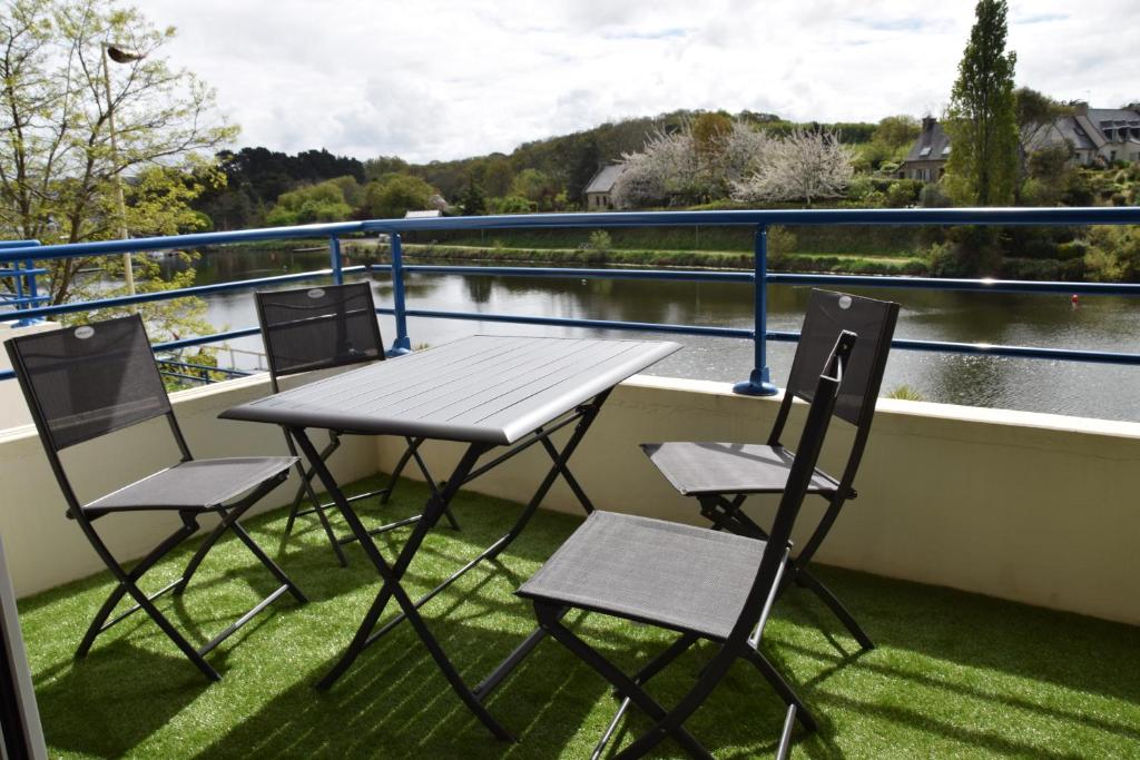 uma mesa e cadeiras numa varanda com vista para um rio em les terrasses de Dahouet em Pléneuf-Val-André