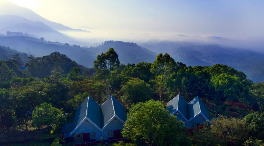 una casa in mezzo a una montagna con alberi di Ambady Estate a Munnar