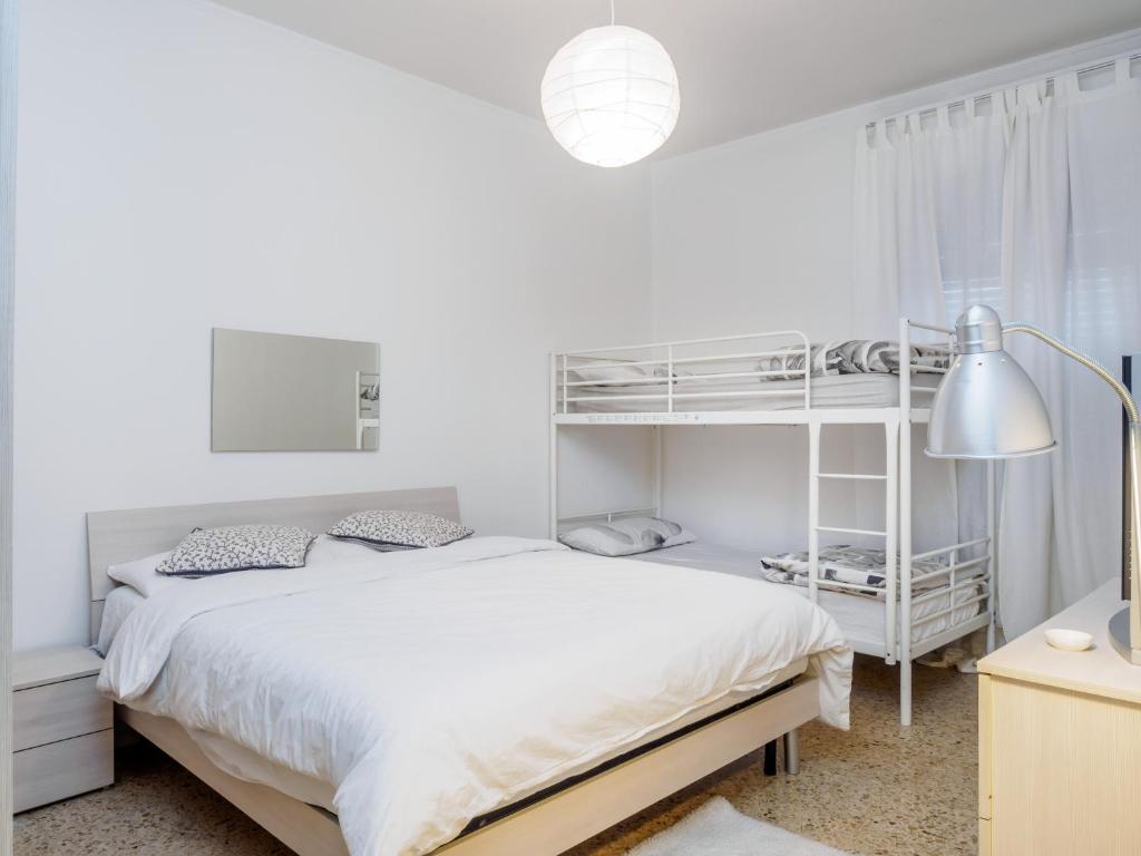 ミラノにあるEnjoy Apartmentの白いベッドルーム(白いベッド1台、二段ベッド付)