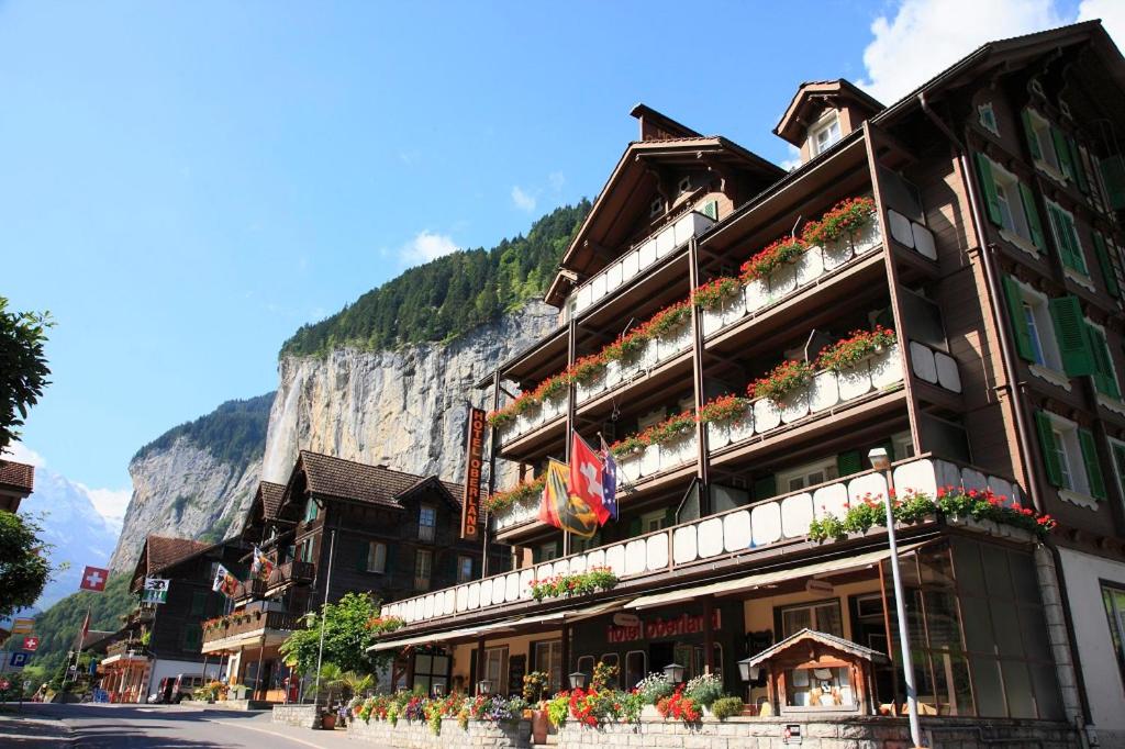 a building with flowers on the side of a street at Hotel Oberland in Lauterbrunnen