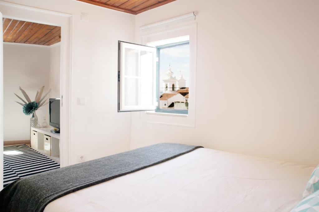リスボンにあるAlfama Apartment Rose - Sardinhaの白いベッドルーム(ベッド1台、窓付)