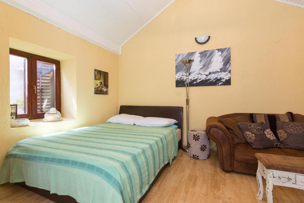 ein Schlafzimmer mit einem Bett und einem Sofa in der Unterkunft Yvonne in Krk