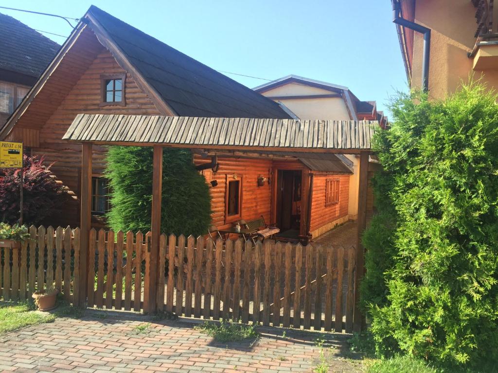 eine Holzhütte mit einem Zaun davor in der Unterkunft Apartmány Ingrid in Bešeňová