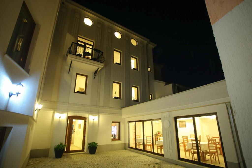 um grande edifício com janelas e uma varanda à noite em Hotel Hana em Mostar
