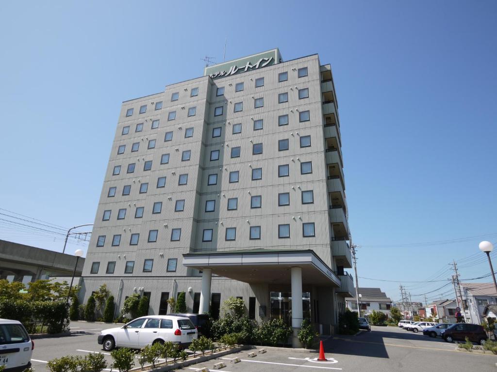 a white car parked in front of a hotel at Hotel Route-Inn Tokoname Ekimae in Tokoname