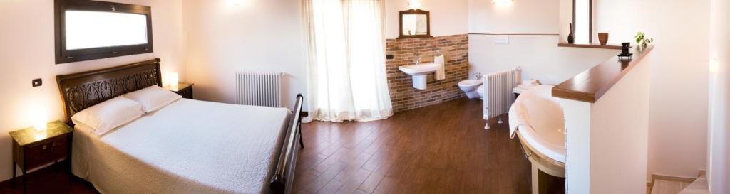 um quarto com uma cama, um lavatório e uma janela em Casa Cipriano large beautiful Apt 120 m2 and small adorable Studio monolocale 23 m2 em Torretta
