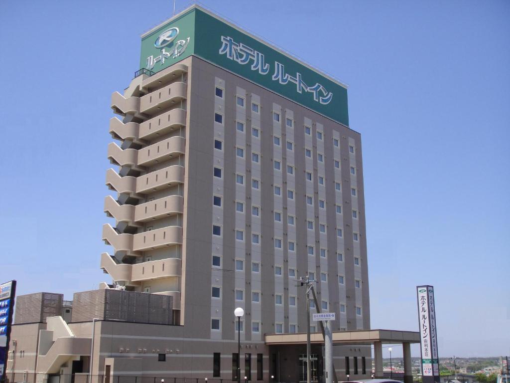 由利本荘市にあるホテルルートイン由利本荘の上に看板があるホテルの建物