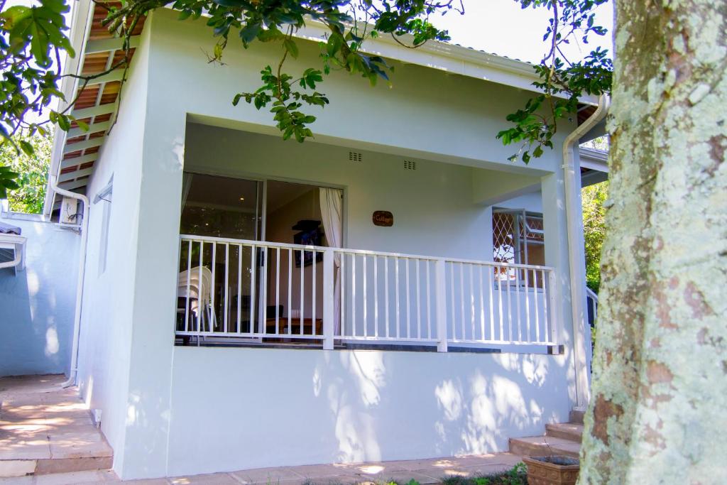 a house with a balcony with a dog in the doorway at Dunranch House in Pietermaritzburg