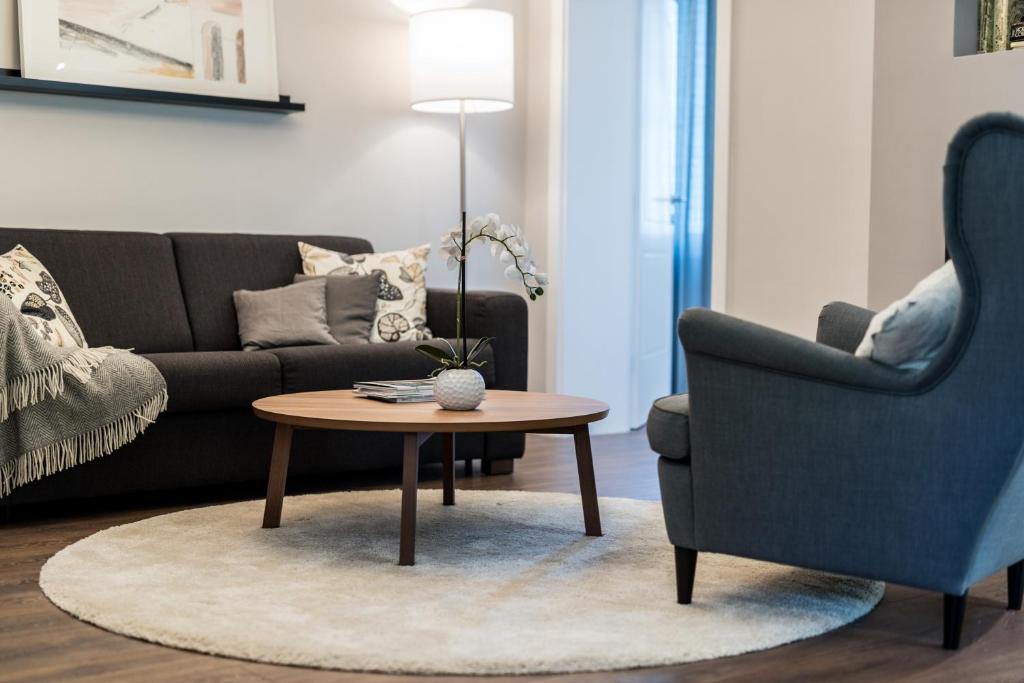 a living room with a couch and a table and a chair at Sunset Beach Apartment in Zadar