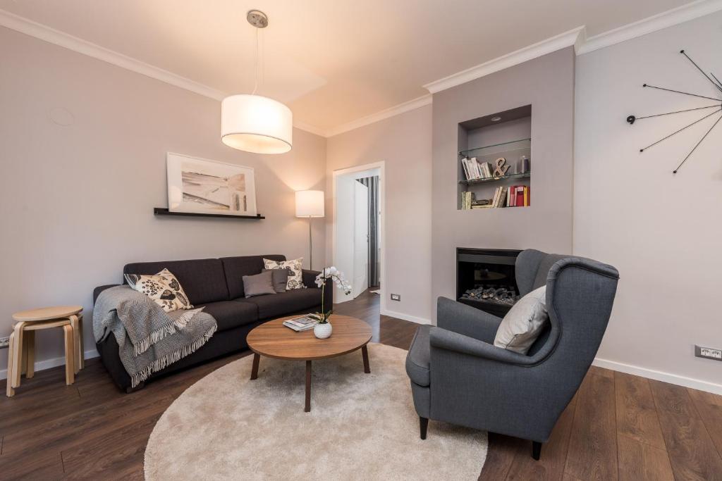 a living room with a couch and chairs and a table at Sunset Beach Apartment in Zadar