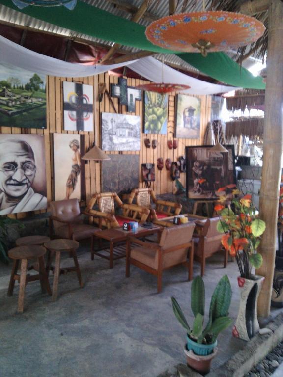 a living room with couches and paintings on the walls at Rakai Garung in Yogyakarta