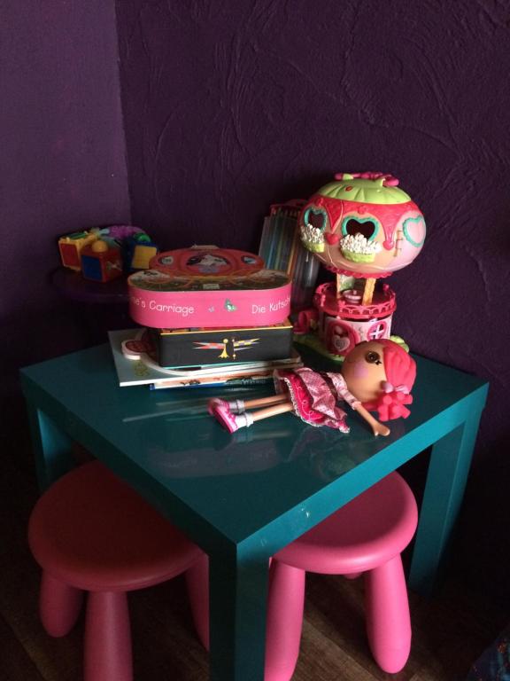 a toy table with two pink stools and a table with a doll at Des goûts et des couleurs in Verviers