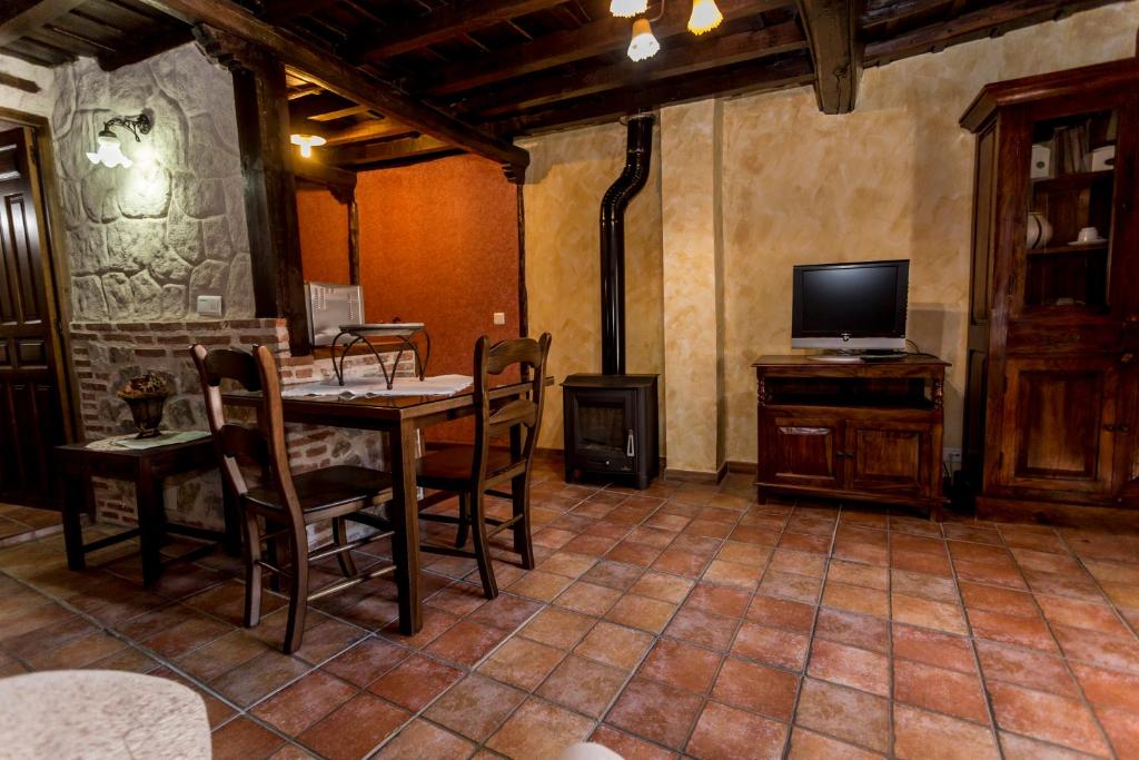a dining room with a table and chairs and a television at casa rural la tramonera in San Esteban de la Sierra