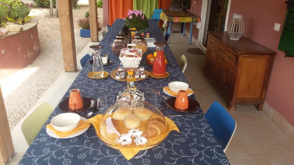 uma mesa longa com uma toalha de mesa azul com comida em SoleeSale Appartamenti e Camere Per Vacanza em Pula