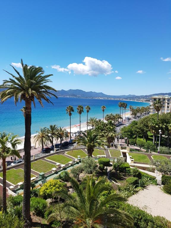 a view of a park with palm trees and the ocean at Cannes Sea View in Cannes