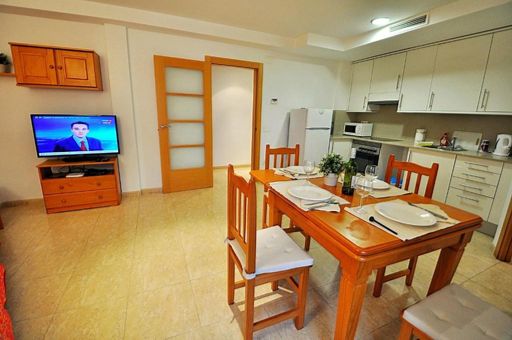 uma cozinha com uma mesa de jantar e uma televisão em Apartment Acacias em Lloret de Mar