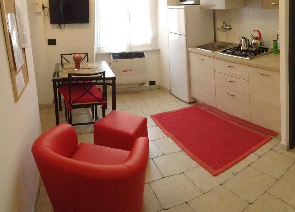 a kitchen with two red chairs and a table and a kitchen at lecasedimarco2 in La Spezia