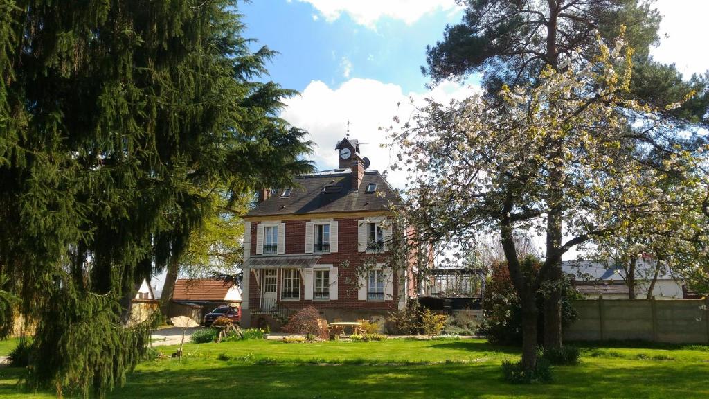 une maison avec une tour d'horloge en haut dans l'établissement Le Jardin Des Erables, à Saint-Marcel