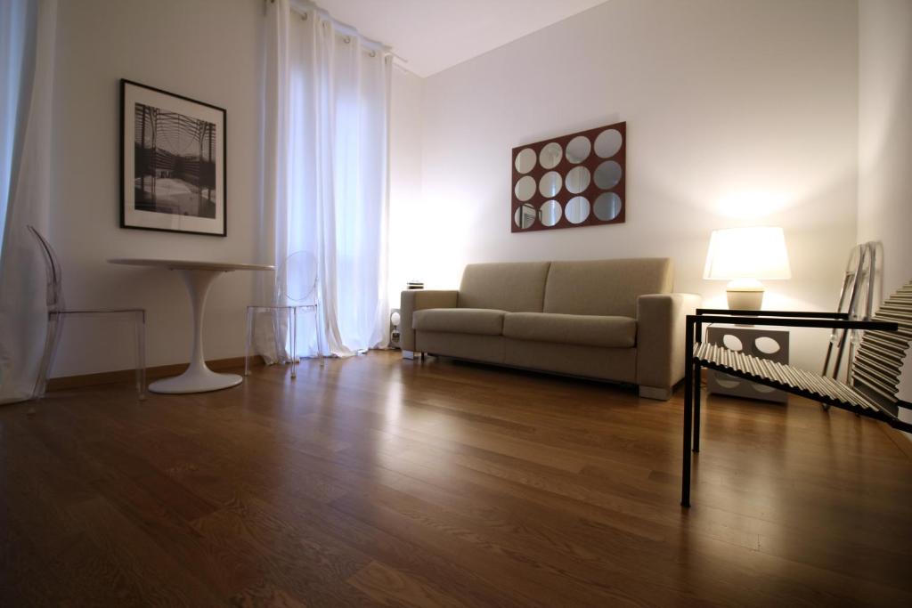 uma sala de estar com um sofá e uma mesa em Brera - Fiori Chiari Charme Apartment em Milão