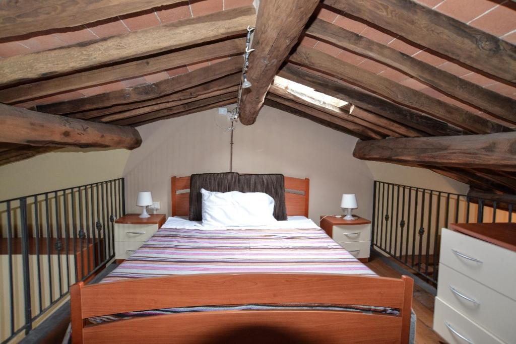 バーニ・ディ・ルッカにあるCasolare Pucciniのベッドルーム1室(梁出し天井の大型ベッド1台付)