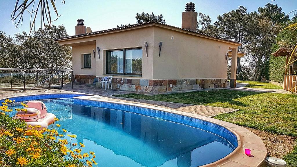 een zwembad voor een huis bij Villa Roselles in Lloret de Mar