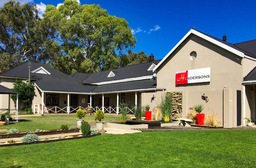 a large white building with a red sign on it at Hendersons Lodge Ltd in Senekal