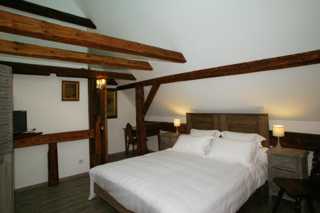 a bedroom with a large white bed with wooden beams at Chambres d'Hôtes La Stoob Strasbourg Sud in Illkirch-Graffenstaden