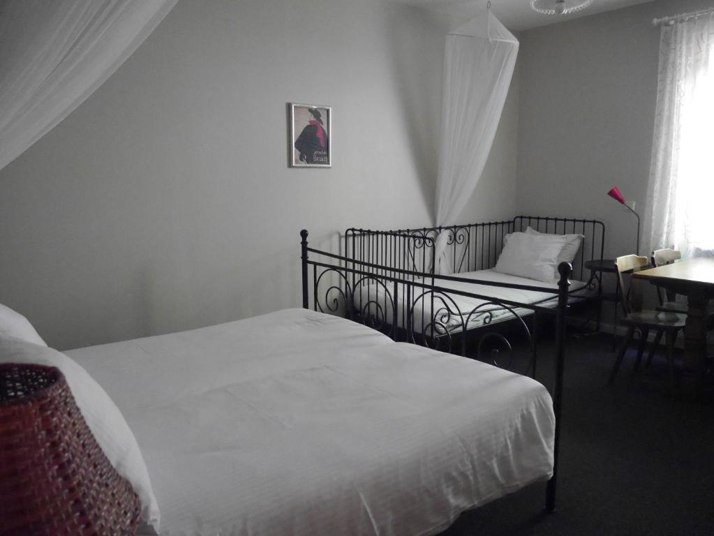 a bedroom with two beds and a chair and a table at Hotel Dirbach Plage in Dirbach