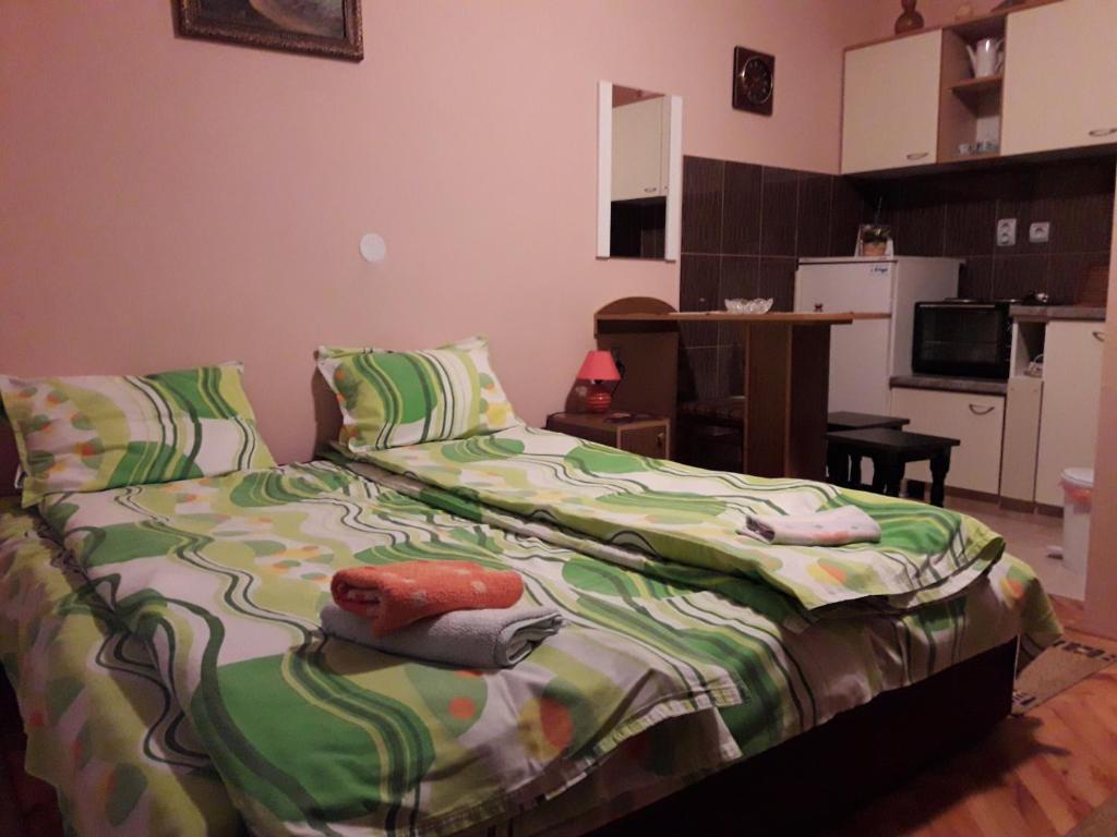 1 dormitorio con 1 cama con edredón verde en Guest House Dunavski Raj, en Kostol