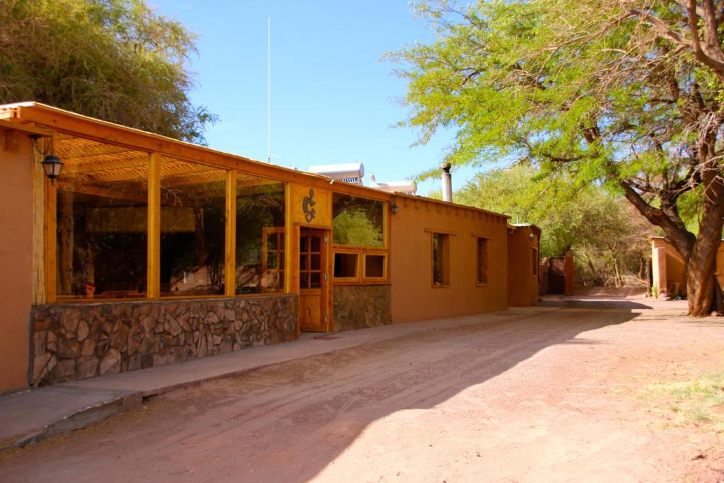 un edificio con ventanas de cristal en un camino de tierra en Terra Luna Atacama, en San Pedro de Atacama