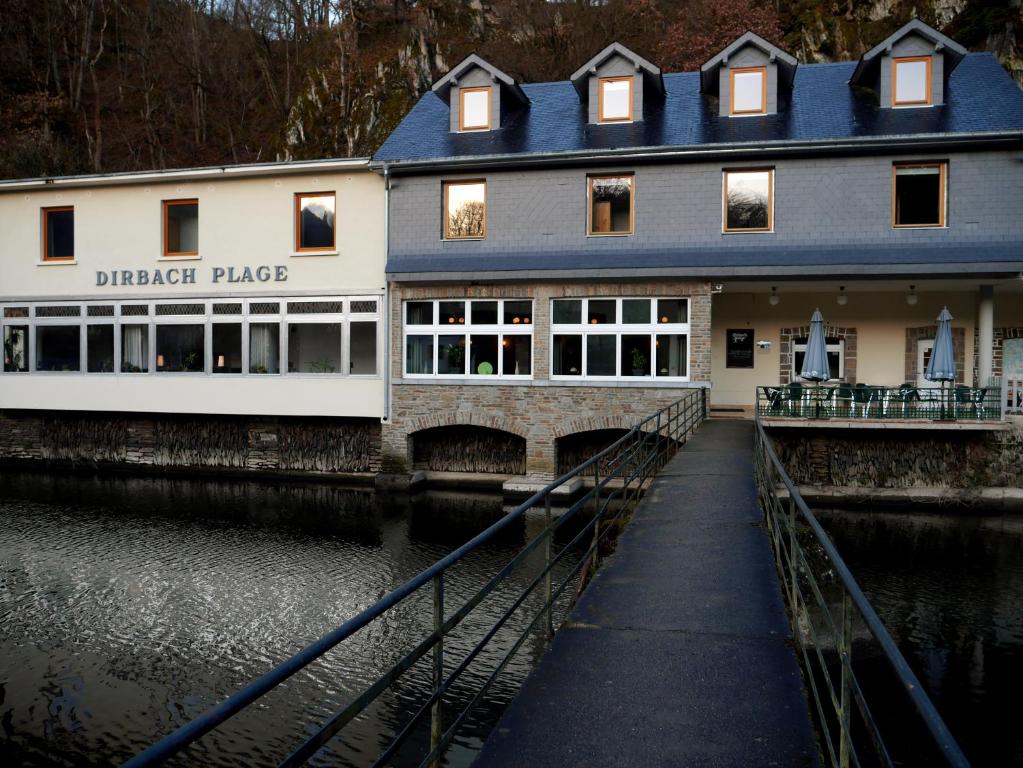 a building that is next to a river at Hotel Dirbach Plage in Dirbach