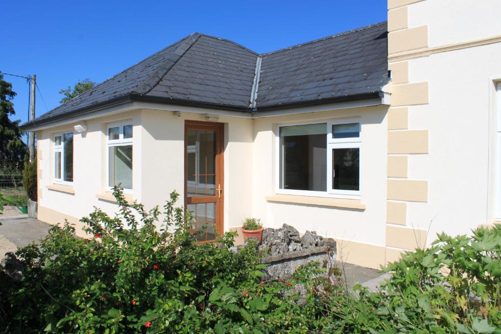 a white house with a black roof at Harry's House in Ballinrobe